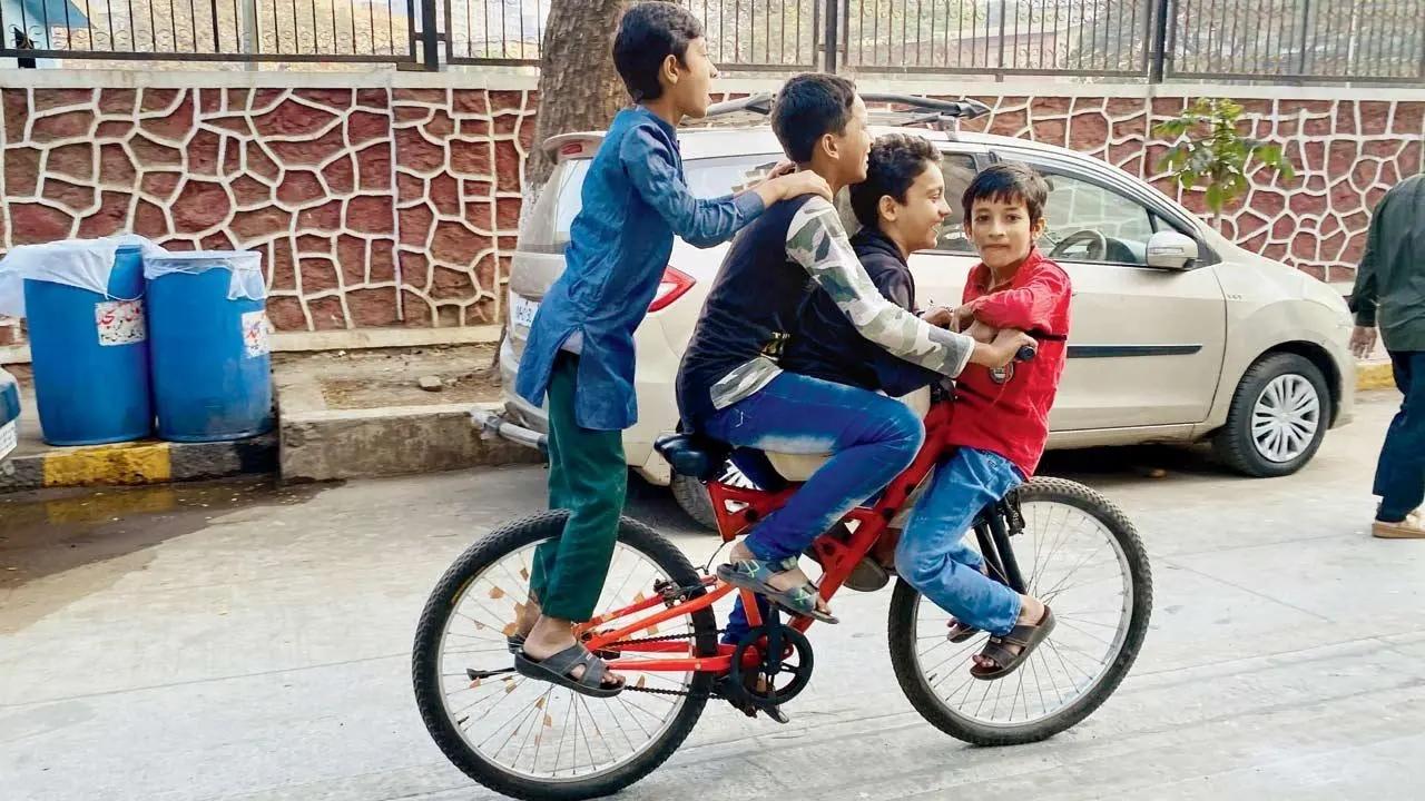 One four All, All four one: Kids play around with a bicycle in Agripada over the weekend. Pic/Shadab Khan